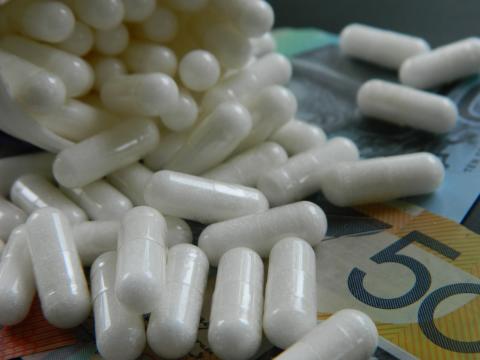photo of white pills and banknotes