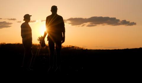 Two people on the land standing silhouetted