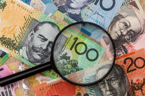 Australian bank notes with magnifying glass over top of notes