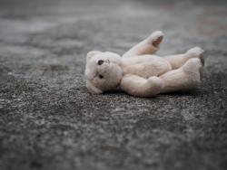 Child's teddy bear laying on the ground