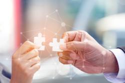 People holding two jigsaw pieces together