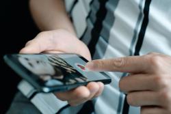 Person selecting heart - like - button on mobile