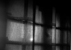 Looking out through darkened window curtains