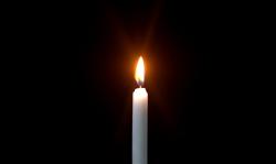 Single candle against black background