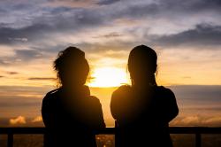 Two women taking photos at sunrise