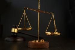 Justice scales in foreground with gavel in background