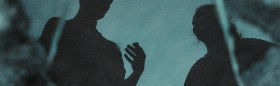 Two people talking in dark