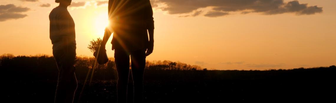Two people on the land standing silhouetted