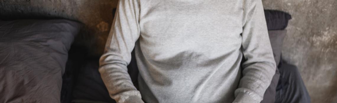 Man sitting on bed typing on keyboard