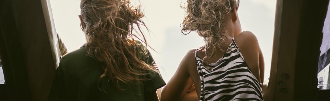 Two children looking out window
