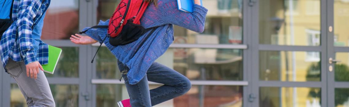 Children running from school with books in hand
