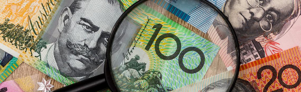 Australian bank notes with magnifying glass over top of notes
