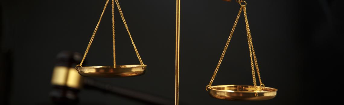 Justice scales in foreground with gavel in background